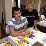 Carol guides 8th grader Joe in art-making.  Joe was a featured artist at a Student Art Show.